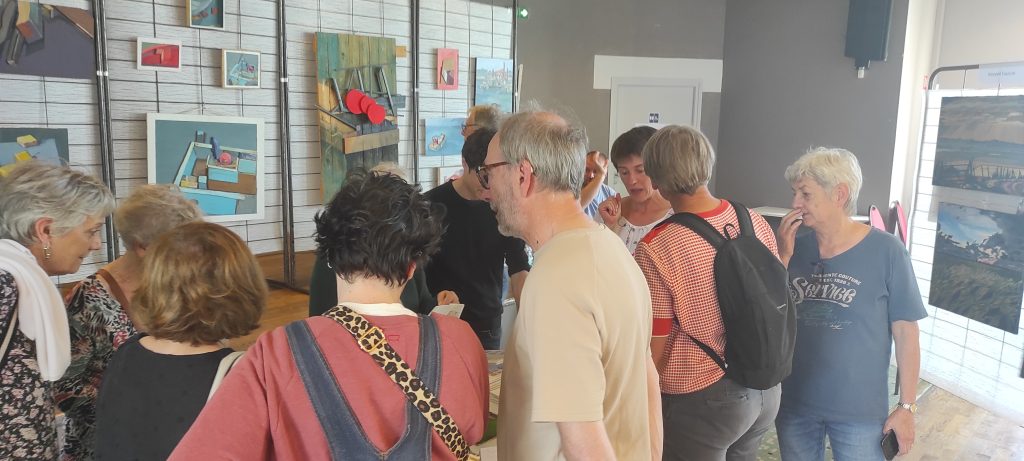 Image montrant le public devant les oeuvres exposées sur les grilles.